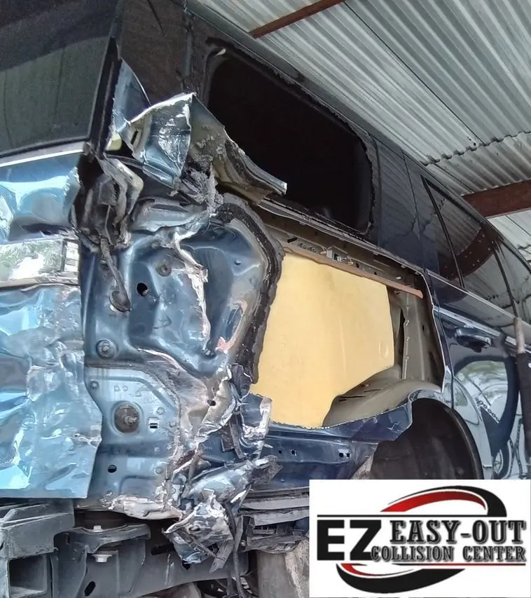 Blue Ford Expedition with severe rear quarter panel impact damage at Easy Out Collision Center