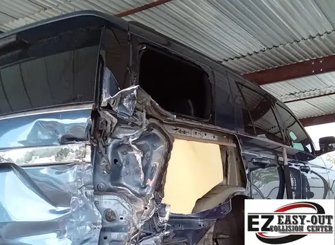 Blue Ford Expedition with a crushed rear side panel and missing quarter window